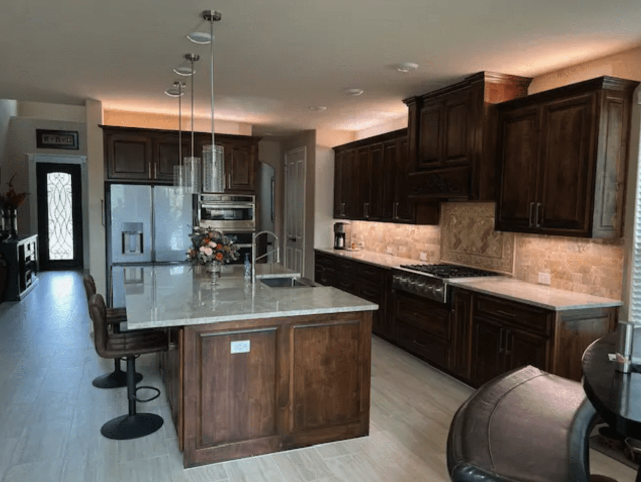 A modern kitchen with wooden flooring and brown interiors